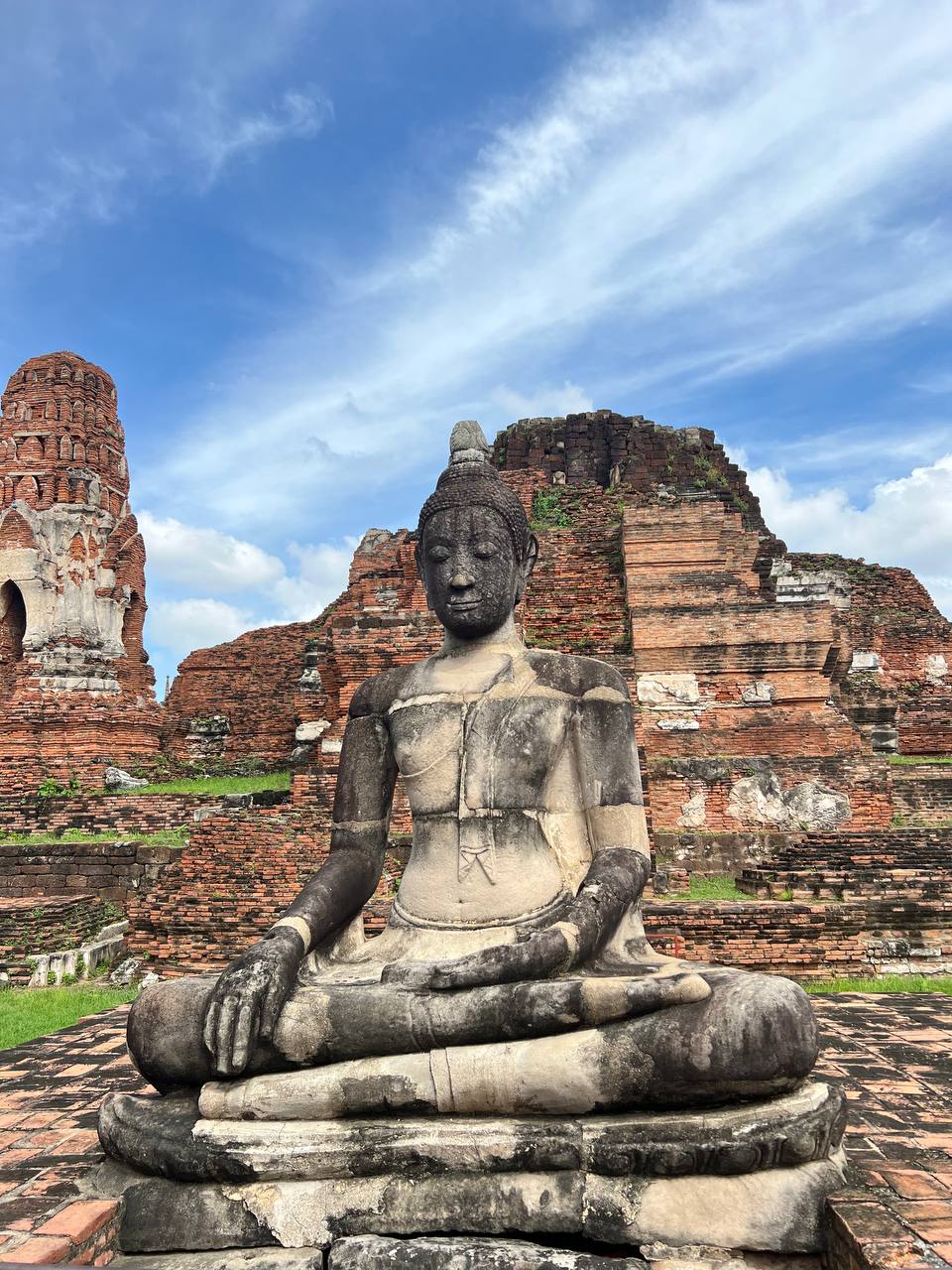Ancient Buddha statue with brick tower ruins, Ayutthaya