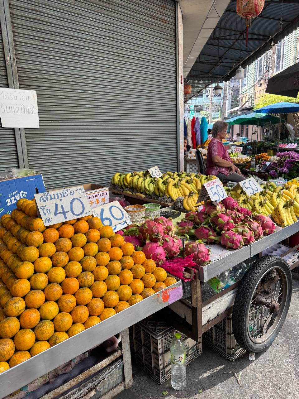 Fruit cart at a Bangkok market — oranges 40 THB, dragon fruit 60 THB